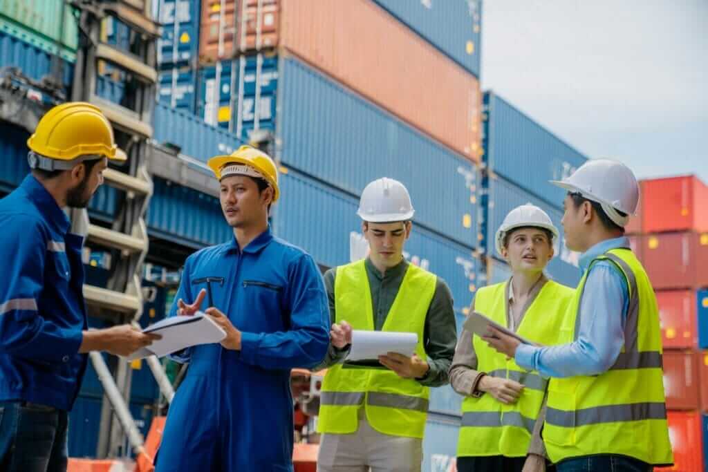 Foremans are discussing for stack container at cargo site logistics service transportation.
